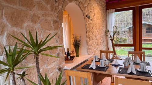 una sala da pranzo con un tavolo e un muro di pietra di Haus am Heubach a Bad Staffelstein