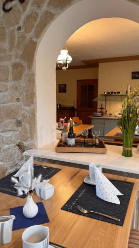 una sala da pranzo con un tavolo e un muro di pietra di Haus am Heubach a Bad Staffelstein