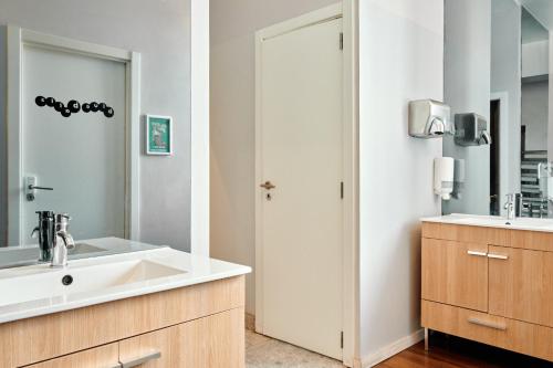 un bagno con lavandino e specchio di Gspot Hostels & Love Triangles Pizzeria a Lisbona