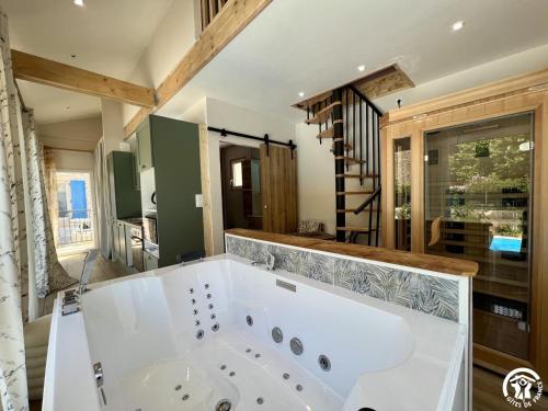 une grande salle de bain avec une grande baignoire dans une pièce dans l'établissement Sous les toits, à Canet d'Aude