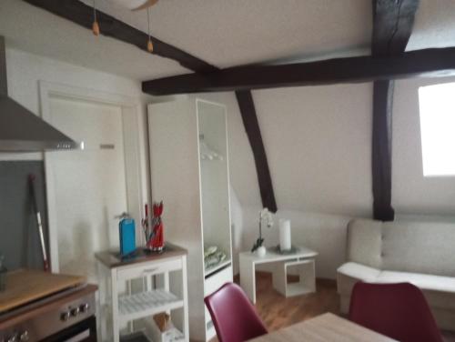 a living room with red chairs and a room with a table at Gästeoase einfach wohl fühlen in Wolfhagen