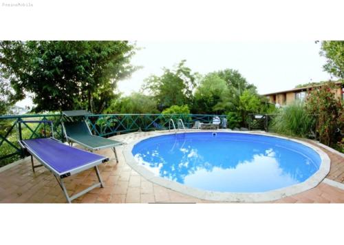 una pequeña piscina azul con una silla y una mesa en Hotel Antico Residence Roma, en Monterosi