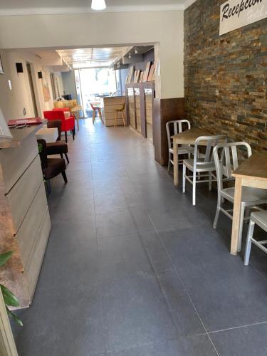 een restaurant met tafels en stoelen en een bakstenen muur bij Hotel Stella in Talca