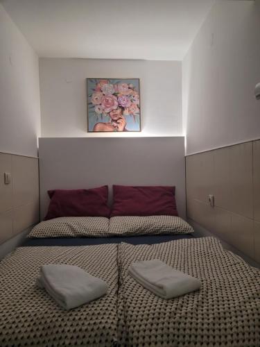 a bedroom with a bed with two pillows on it at APARTMANI Emerald Dream in Novi Sad