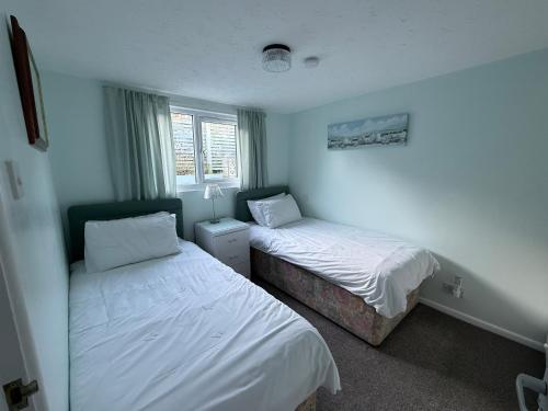a bedroom with two beds and a window at 92 Blueberry Lodge - Sea Views in Westward Ho