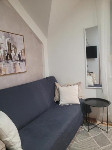 a blue couch in a living room with a table at APARTMANI Emerald Dream in Novi Sad