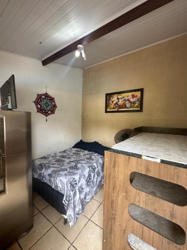 a small bedroom with a bed and a refrigerator at Pousada em Itupeva in Itupeva