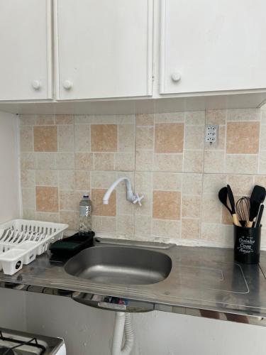 d'un comptoir de cuisine avec un évier et des placards blancs. dans l'établissement Linhares beach, à Cabedelo