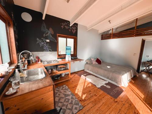 een keuken met een wastafel en een bed in een kamer bij Tiny House Al lado del río in Linares