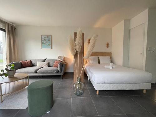 a living room with a bed and a couch at Les pieds dans l'eau in Thonon-les-Bains
