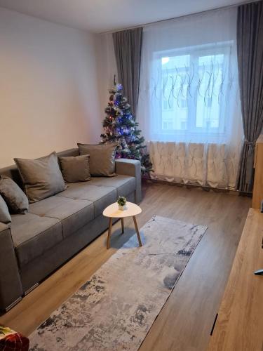 a living room with a christmas tree and a couch at Lily Ap in Lupeni