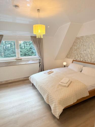 une chambre avec un lit et deux fenêtres dans l'établissement Fichtenblick, à Selb