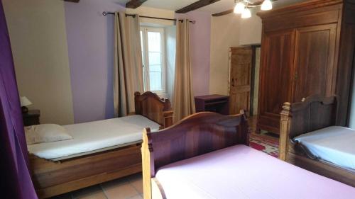 une chambre avec deux lits et une fenêtre dans l'établissement Le grand gite de souels, à Almayrac