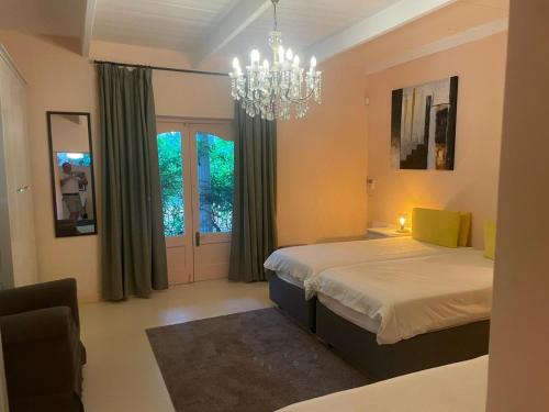 une chambre avec un lit et un lustre dans l'établissement Villa Olivia, à Riebeek-Kasteel