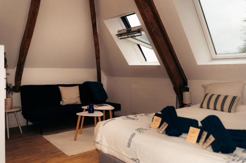 Zimmer im Dachgeschoss mit 2 Betten und einem Sofa in der Unterkunft Maison Le Catelier in Le Catelier