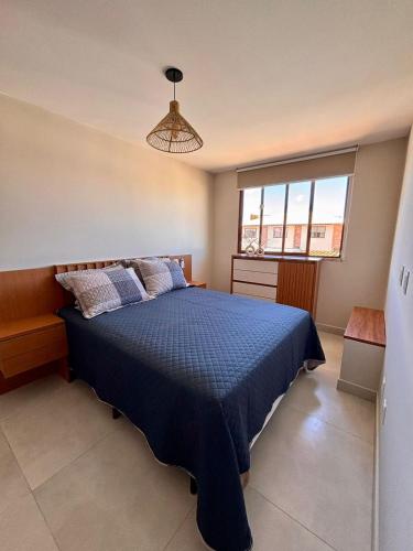 a bedroom with a blue bed and a window at 2 QUARTOS, Condomínio Villa de Rodes IMBASSAÍ Super bem localizado, Próximo a PRAIA, FARMÁCIAS, MERCADO E RESTAURANTES in Imbassai