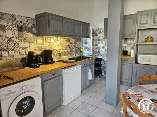 a kitchen with a washing machine and a sink at Roumanieu le gite in Saint-Gauzens