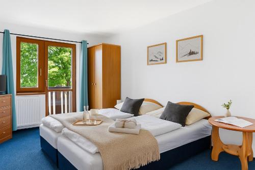 een slaapkamer met een groot wit bed en een tafel bij REJVÍZ 1 Hotel & Spa in Rejvíz