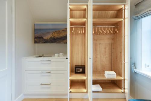 een kast met witte laden en een houten deur bij Strandhafer in List