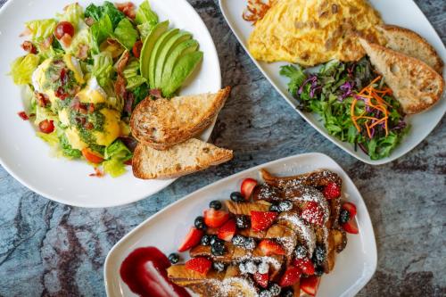 een tafel met drie borden eten erop bij Martinique New York on Broadway, Curio Collection by Hilton in New York