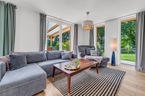 a living room with a couch and a table at Haus am Seeufer mit Badestelle in 200m, große Sonnenterrasse, umzäunter Garten, Hunde willkommen in Rheinsberg