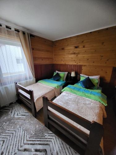 a bedroom with two beds and a window at Old Town House! in Žabljak