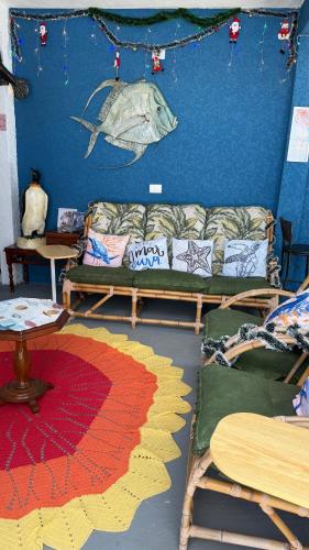 a living room with a couch and a fish on the wall at Pousada Mar e Sol in Peruíbe
