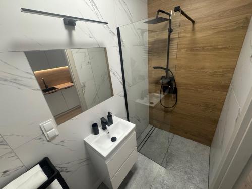 een witte badkamer met een wastafel en een douche bij Żurawie II Popiełuszki 2A 51 in Gdańsk