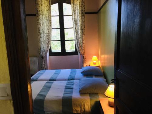 een slaapkamer met een bed en een raam bij Ancienne ecole de moncere in Penne