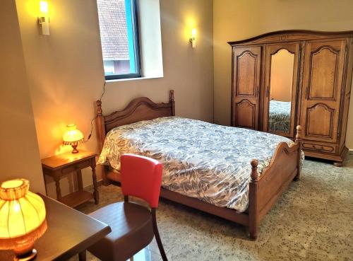a bedroom with a bed and a table and a chair at La Friandise in Seppois-le-Bas