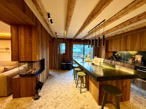 a kitchen with a counter and some chairs in a room at Chalet Oslo by Lodji in Saint-Marcel