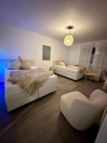a bedroom with two beds and a couch and a chair at Little Royal in Garbsen