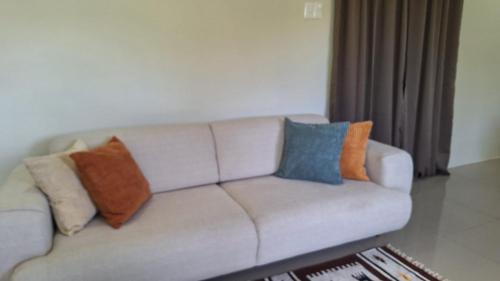 een bank met kussens erop in een woonkamer bij Windy Hill Suites in Bacolet