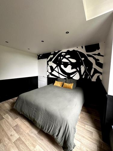 a bedroom with a bed with a tree mural on the wall at Appartement - Le Prestige in Saint-Chéron