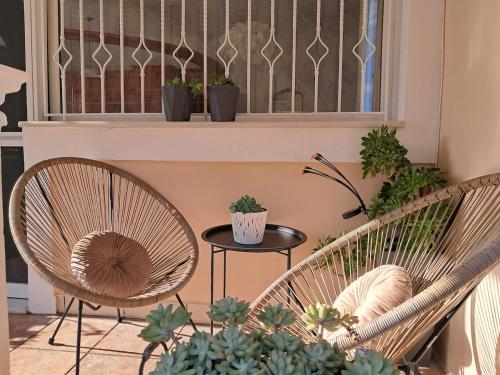 Twee stoelen en een tafel met potplanten op een balkon. bij Sundora Sweet Home in (( Agía Eleoúsa ))