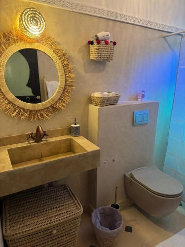 a bathroom with a sink and a toilet and a mirror at Riad Douha in Marrakesh