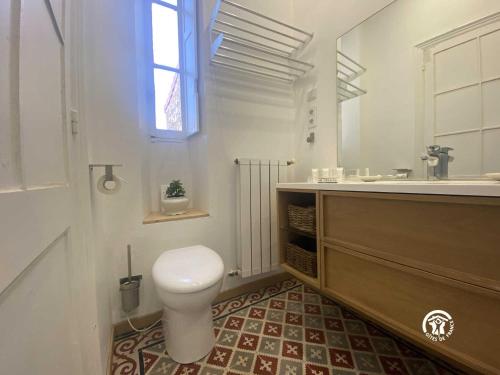 een badkamer met een toilet, een wastafel en een spiegel bij La maison bachelet in Claira