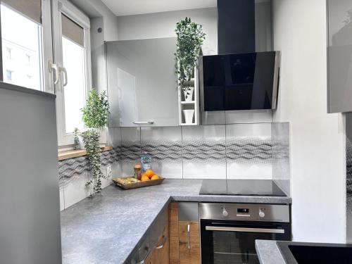 a kitchen with white cabinets and a counter top at Apartament Pastelowy Tukan in Kwidzyn