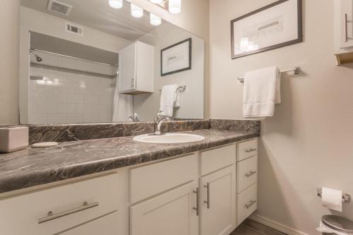 een badkamer met een wastafel en een spiegel bij Landing Stylish 1BD Courtyard Pool in Broken Arrow