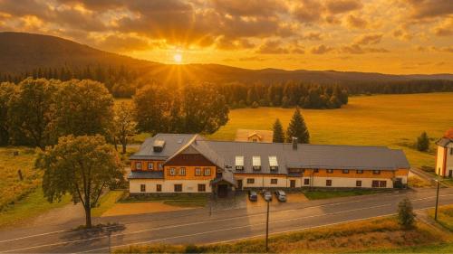 an aerial view of a building with the sunset in the background at REJVÍZ 1 Hotel & Spa in Rejvíz