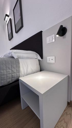 a bedroom with a bed with a white night stand at Mediterranea Apartments Sunrise in Assemini