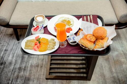 een dienblad met borden eten en drinken op een tafel bij Hotel Lubumbashi in Lubumbashi