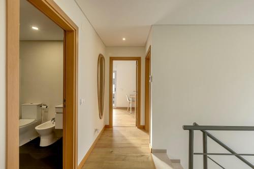 een hal van een badkamer met een toilet en een wastafel bij Bright & Airy 3BR Spacious Villa in Sesimbra
