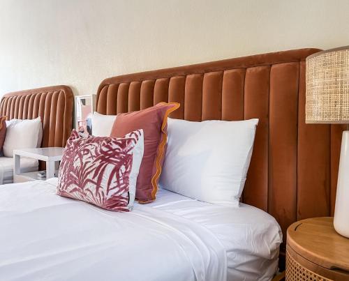 a bed with white sheets and pillows at Ocean Lodge in Boca Raton