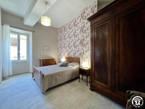 ein Schlafzimmer mit einem Bett, einer Kommode und einem Fenster in der Unterkunft Chez madou in Roquefort-des-Corbières