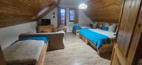 a room with three beds and a living room with a couch at Skiprivat in Ružomberok
