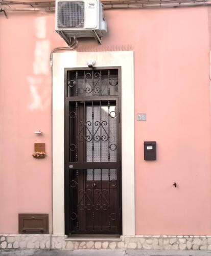 a black door on a pink building with at Casa Naida in Nardò