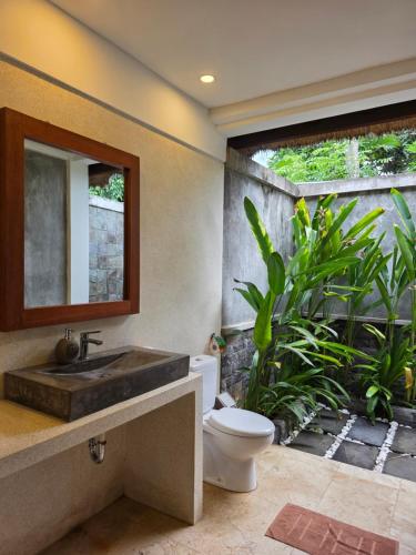 een badkamer met een wastafel en een toilet bij Guava Garden in Gili Trawangan