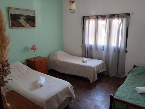 een kamer met twee bedden en een raam bij Casa de playa. Quequen in Quequén