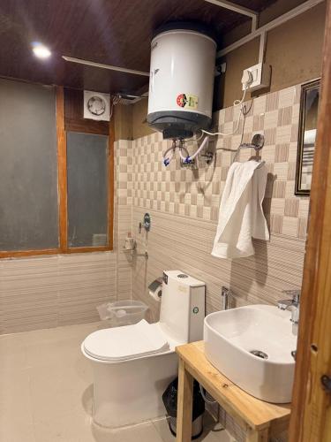 a bathroom with a toilet and a sink at Mountain Nest Stay in Jibhi